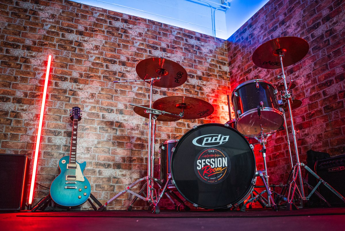 The Session Room live room — drum kit against a brick wall